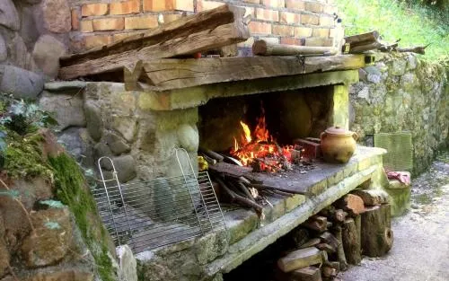 Spoljni kamin i prostor za roštilj u dvorištu Etno-kuće Leka