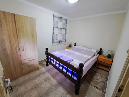 Spavaća soba sa velikim bračnim krevetom i toplim drvenim detaljima
